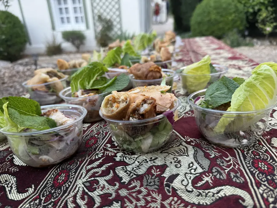 Buffet traiteur Chana Thai dressé sur nappe brodée : bouchées, salades et verrines