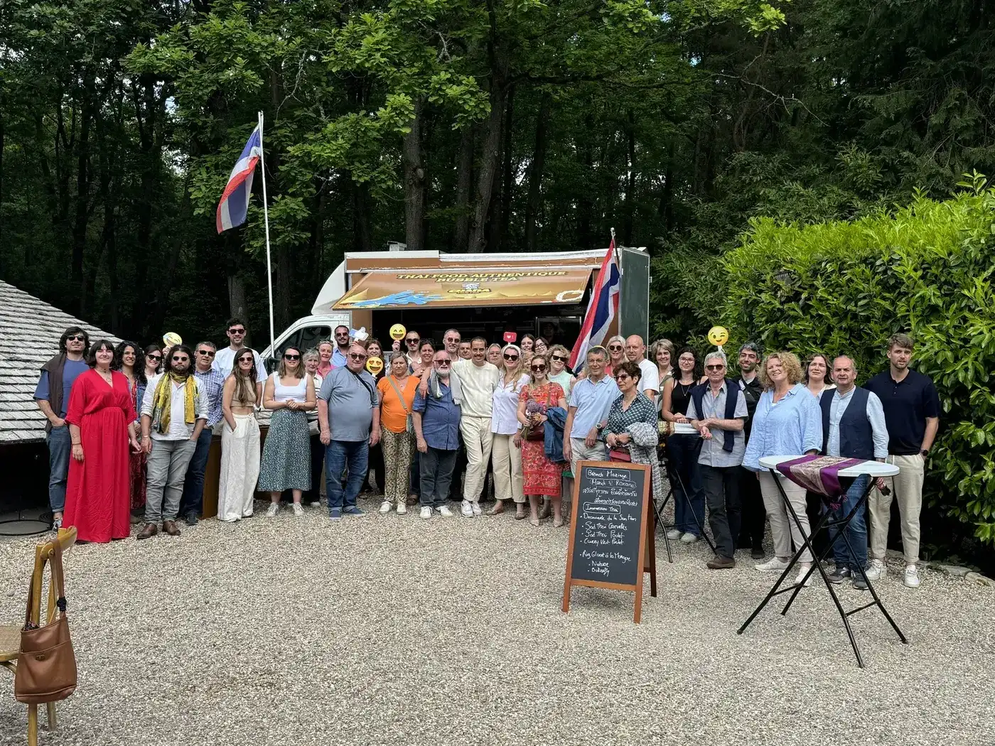 Les invités d'une réception privée réunis devant le food truck Chana Thai, drapeau thaï déployé